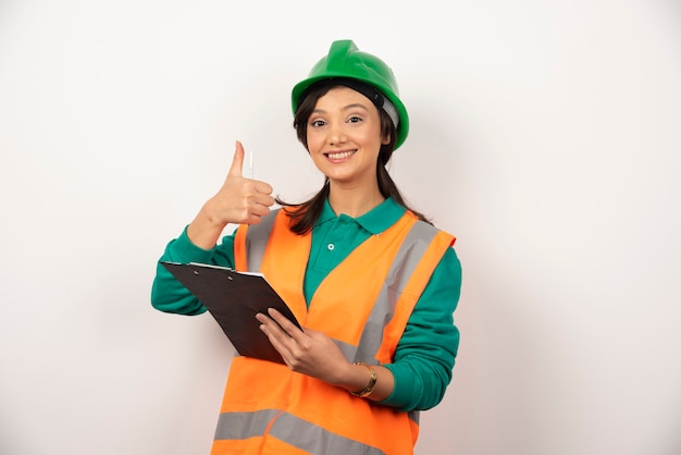 Kostenloses Foto positive weibliche wirtschaftsingenieurin in uniform mit zwischenablage auf weißem hintergrund.