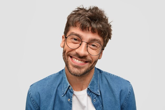 Positiver bärtiger Mann mit freundlichem Lächeln, der in Hochstimmung ist und Freizeit verbringt