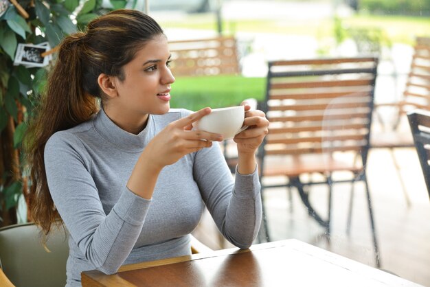 Positiver junger Unternehmer trinkt Kaffee