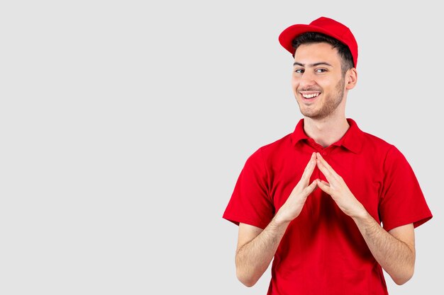 Positiver Mann in roter Uniform, der vorne steht und schaut