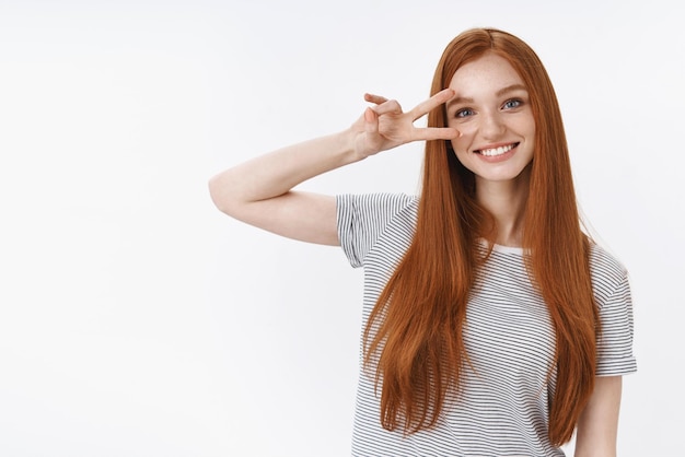 Positives süßes optimistisches rothaariges Teenager-Mädchen haben Spaß daran, die Geste des Friedenssieges zu zeigen