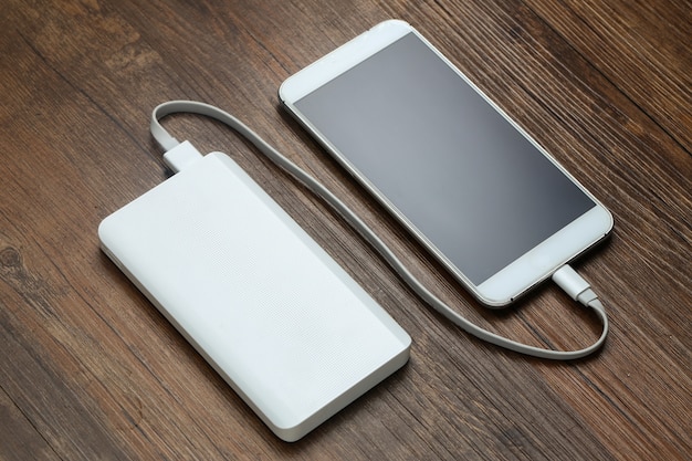 Powerbank und handy auf hölzerner tisch