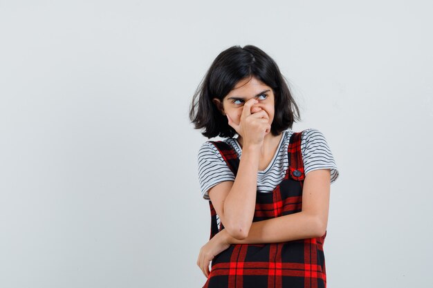 Preteen Mädchen bedeckt ihren Mund und Nase mit der Hand, während in T-Shirt wegschauen