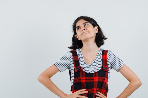 Kostenloses Foto preteen mädchen, das weg schaut, während hände auf ihrer taille im t-shirt halten