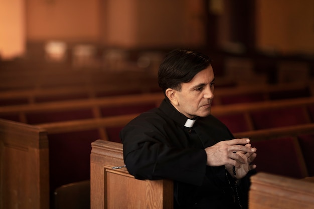 Kostenloses Foto priester, der in der kirche betet