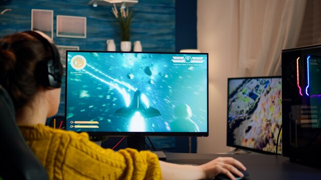 Pro Cyber-Sport-Gamer, der ein Spiel mit RGB-Tastatur und -Maus spielt. Virtuelle Shooter-Spielmeisterschaft im Cyberspace, eSports-Spieler, die während des Gaming-Turniers auf dem Computer in einem stilvollen Raum auftreten