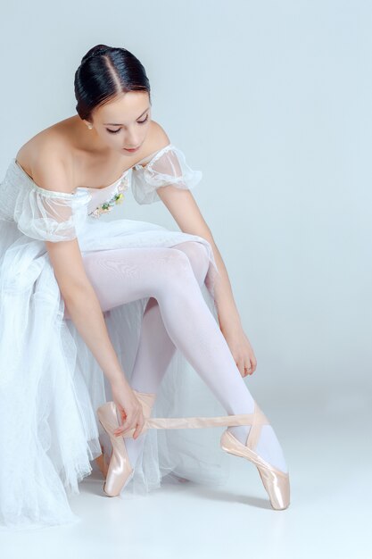 Professionelle Ballerina, die ihre Ballettschuhe anzieht