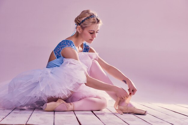 Professionelle Ballerina, die ihre Ballettschuhe anzieht