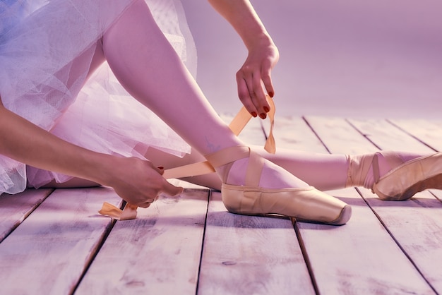 Professionelle Ballerina, die ihre Ballettschuhe anzieht.