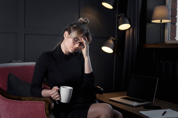 Professionelle Geschäftsfrau mit Kopfschmerzen im Büro