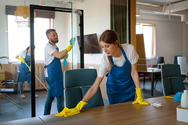 Kostenloses Foto professionelle reinigungskräfte arbeiten in einem büro zusammen