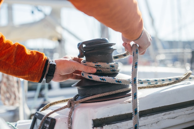 Professionelle Segler- oder Seglerstrumpfhose und Spannseil oder Drahtseil auf mechanischer Winde auf Segelboot oder Yacht