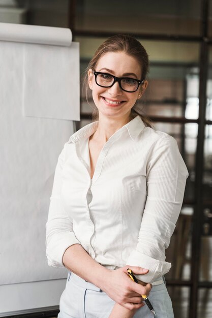 Professionelle Smiley-Geschäftsfrau mit Brille, die eine Präsentation macht