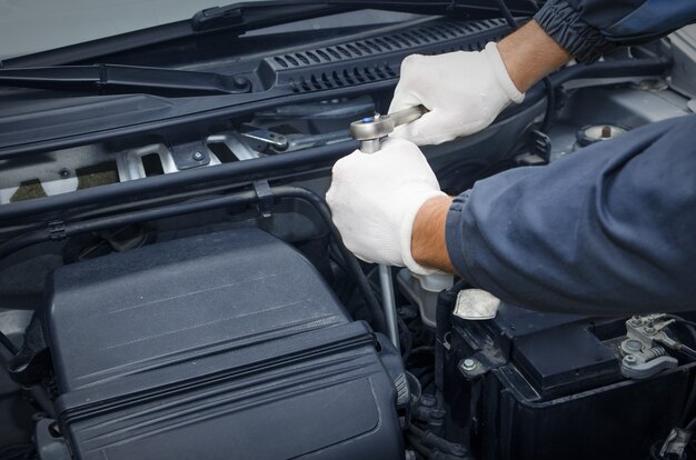 Professioneller Automechaniker in der Werkstatt, die das Auto repariert