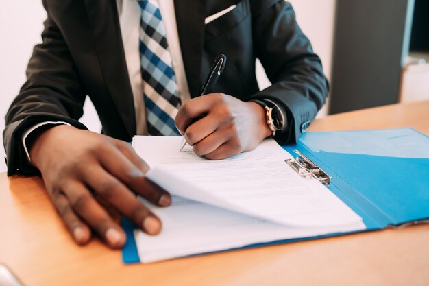 Professioneller Geschäftsmann, der mit Dokumenten in seinem modernen Büro arbeitet