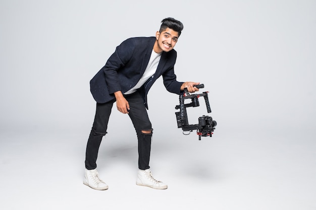 Professioneller indischer Mann Videograf mit Gimball Video SLR Ronin isoliert auf Studio Hintergrund