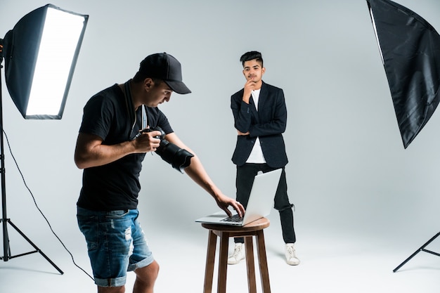 Professioneller junger Fotograf, der Fotos des indischen Modells im Studio mit Leight macht