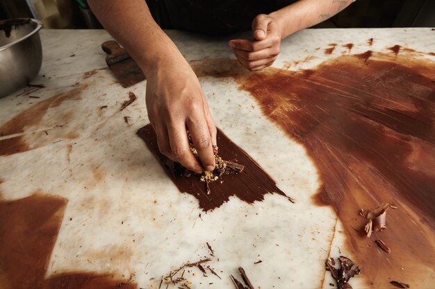 Professioneller Koch arbeitet mit geschmolzener hausgemachter Schokolade