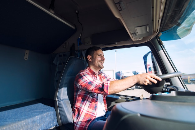 Professioneller LKW-Fahrer mittleren Alters in Freizeitkleidung, der LKW-Fahrzeug fährt und Fracht zum Ziel liefert