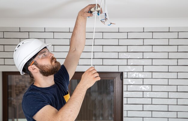 Professioneller Overall mit Werkzeugen im Hintergrund der Reparaturstelle. Hausrenovierungskonzept.