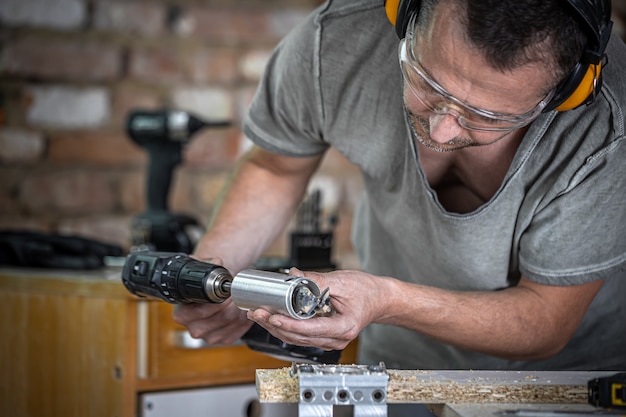 Professioneller Tischler, der mit einem Scharnierbohrer arbeitet, mit Holz arbeitet