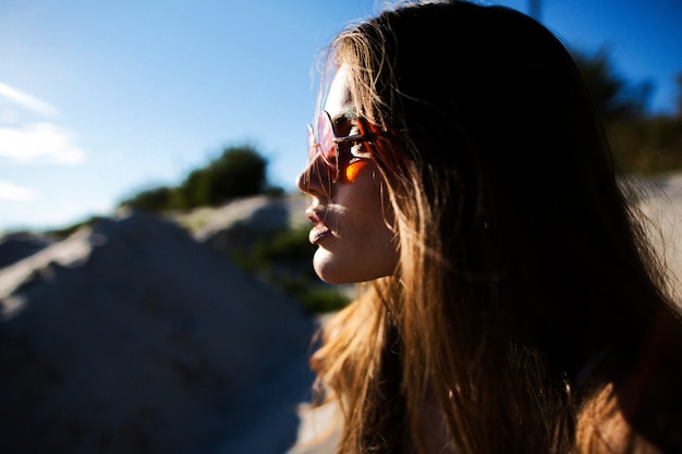 Profil der hübschen Frau in roten Sonnenbrillen