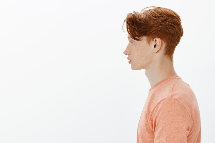 Kostenlose Foto profil des hübschen rothaarigen jungen männlichen studenten, mann, der links schaut