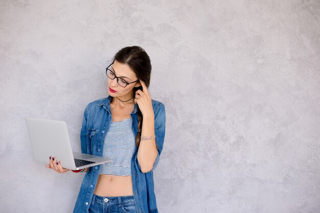 Profilansicht einer denkenden Frau mit Laptop