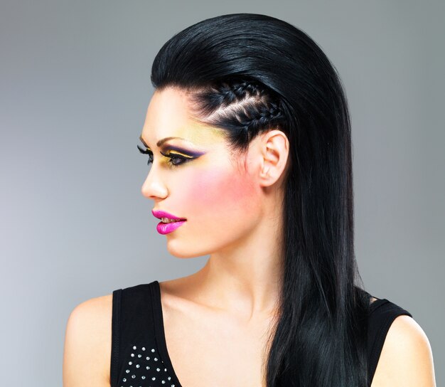 Profilporträt einer Frau mit Mode-Make-up auf Gesicht und schwarzen glatten Haaren