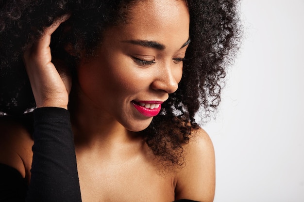 Profilporträt einer schwarzen Frau mit lockigem Haar, die beiseite schaut