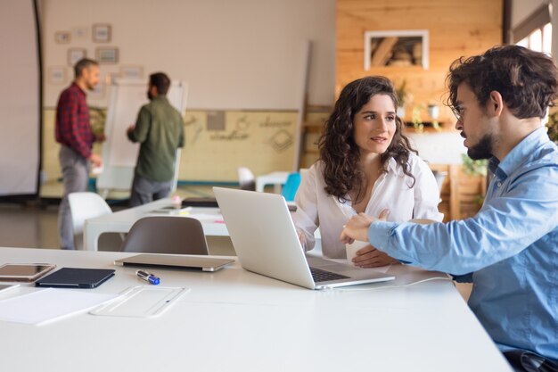 Projektpartner diskutieren Ideen und nutzen gemeinsam den Laptop