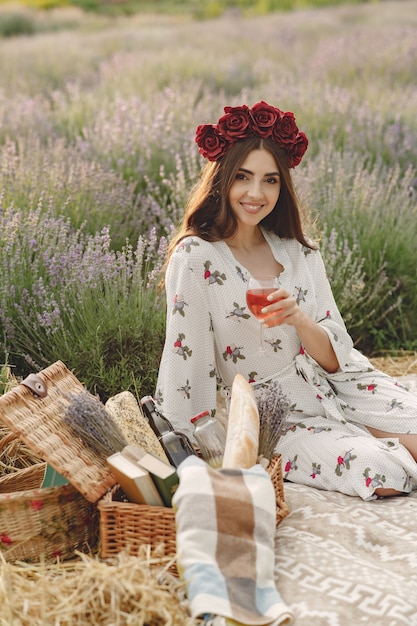 Provence Frau, die im Lavendelfeld entspannt. Dame in einem Picknick. Frau in einem Blumenkranz.