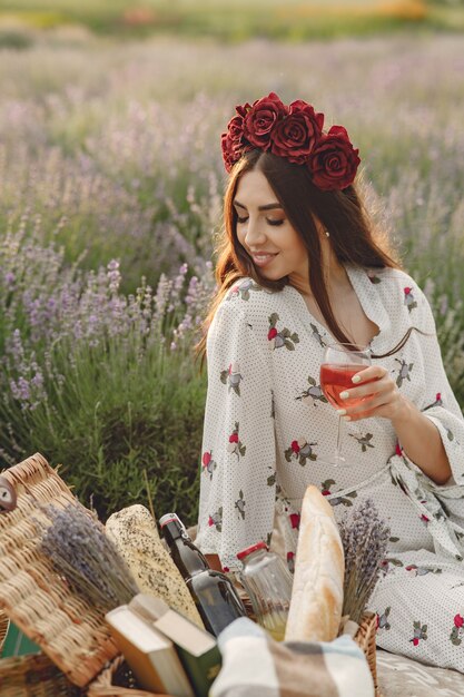 Provence Frau, die im Lavendelfeld entspannt. Dame in einem Picknick. Frau in einem Blumenkranz.