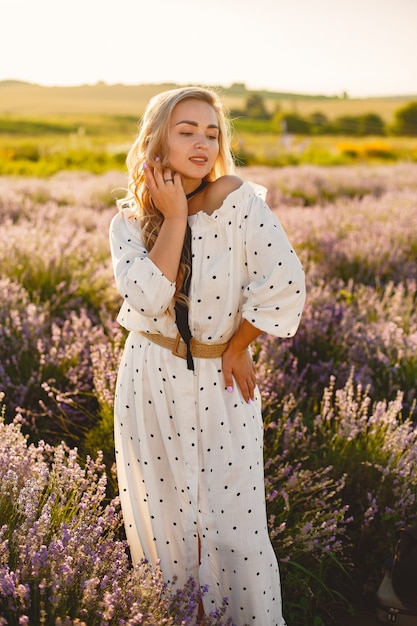 Provence Frau, die im Lavendelfeld entspannt. Dame in einem weißen Kleid. Mädchen mit einem Strohhut.