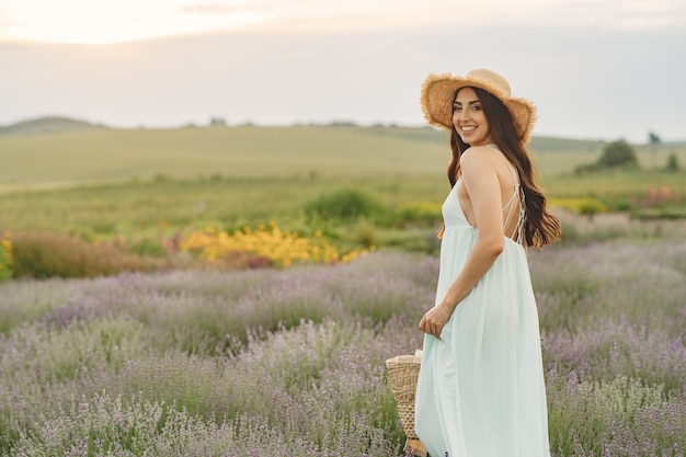 Provence Frau, die im Lavendelfeld entspannt. Dame mit Strohhut. Mädchen mit Tasche.