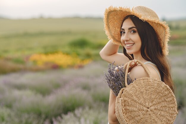 Provence Frau, die im Lavendelfeld entspannt. Dame mit Strohhut. Mädchen mit Tasche.