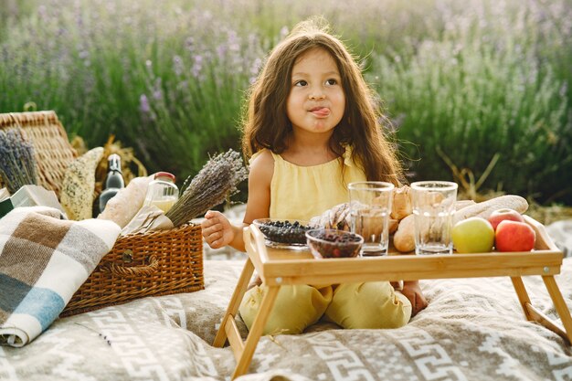 Provence Kind, das im Lavendelfeld entspannt. Kleines Mädchen in einem Picknick.