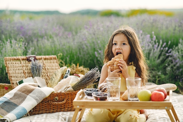 Provence Kind, das im Lavendelfeld entspannt. Kleines Mädchen in einem Picknick.
