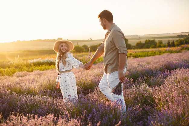 Provence-Paar, das sich im Lavendelfeld entspannt. Dame in einem weißen Kleid.