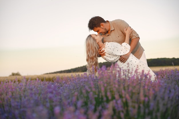 Provence-Paar, das sich im Lavendelfeld entspannt. Dame in einem weißen Kleid.