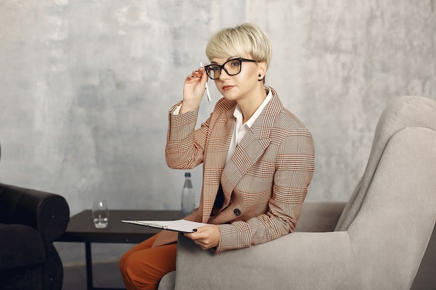 Psychologe mit Brille sitzt auf einem Stuhl im Büro