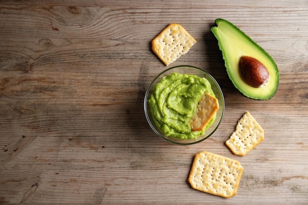 Pürierte Avocado-Guacamole-Sauce in Schüssel mit Crackern