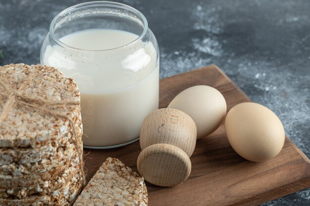 Puffreiskuchen, Milch und Eier auf Holzbrett