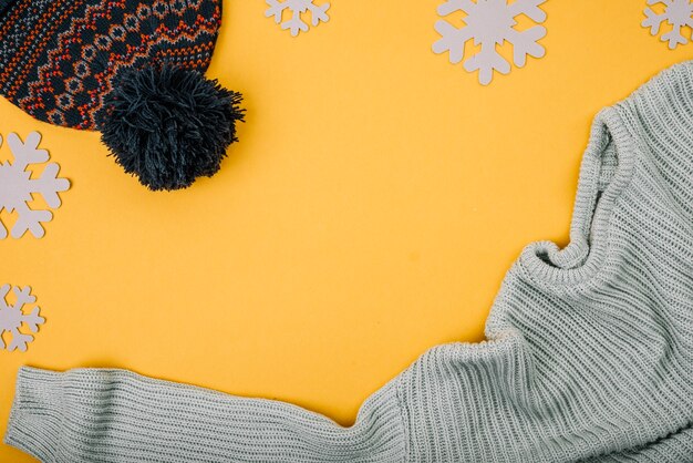 Pullover und Bommel Hut in der Nähe von Schneeflocken