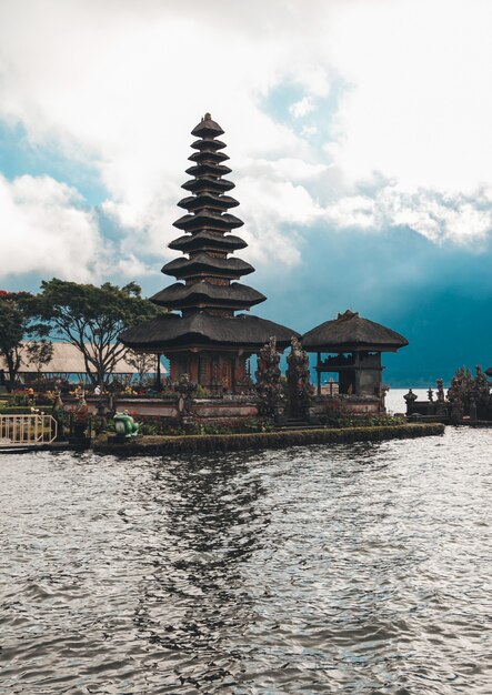 Pura Ulun Danu Bratan, Bali. Hinduistischer Tempel, umgeben von Blumen am Bratan See