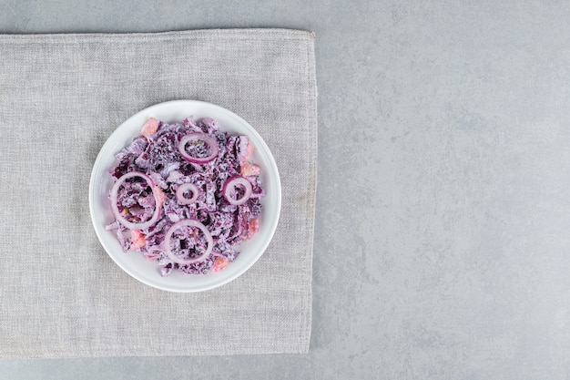 Purpurkohl-Zwiebel-Salat mit verschiedenen Zutaten in Keramikbechern.