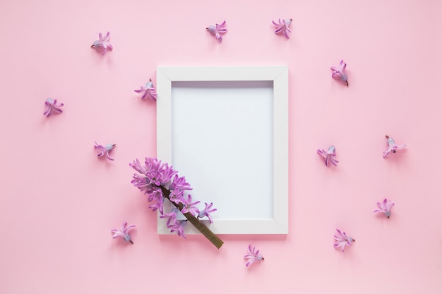 Kostenloses Foto purpurrote blumenniederlassung mit leerem rahmen auf tabelle