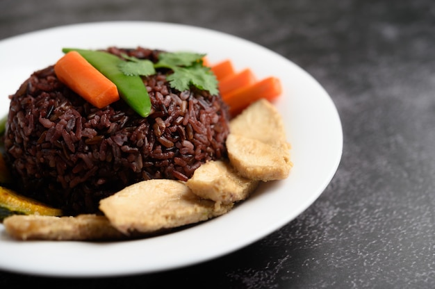 Purpurrote Reisbeeren gekocht mit gegrillter Hühnerbrust. Kürbis, Karotten und Minze in einer Schüssel, sauberes Essen.