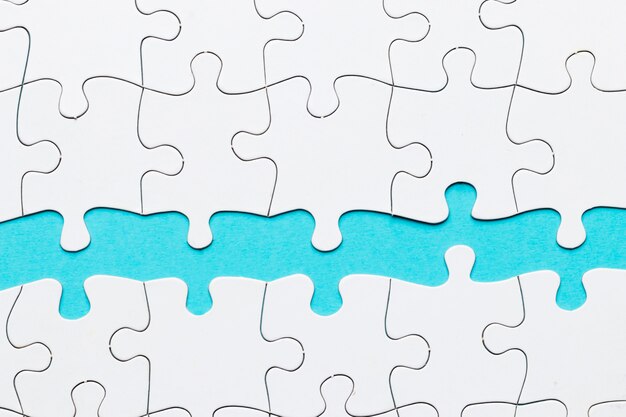 Puzzlestück gegen auf blauen Hintergrund
