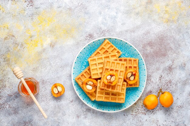 Quadratische belgische Waffeln mit Wollmispelfrüchten und Honig